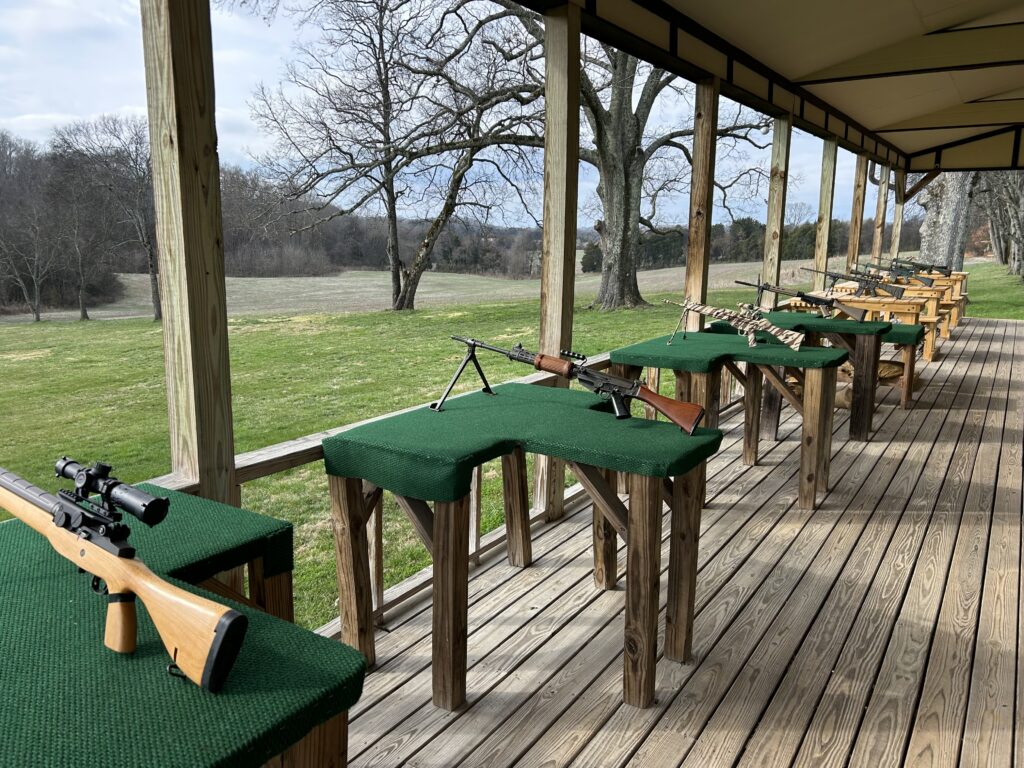 Covered outdoor shooting range facility with wooden benches at Terra Bellum