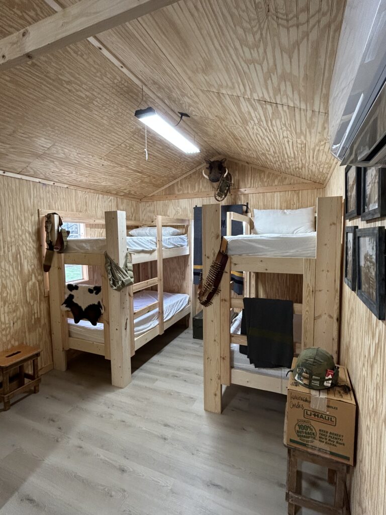 Rustic military style cabin lodging with wooden bunk beds at Terra Bellum