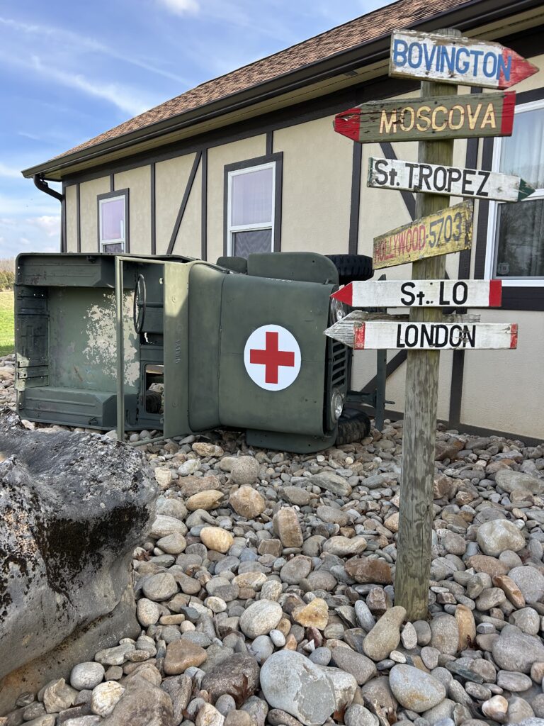Vintage military medical Jeep display with historical directional signpost at Terra Bellum