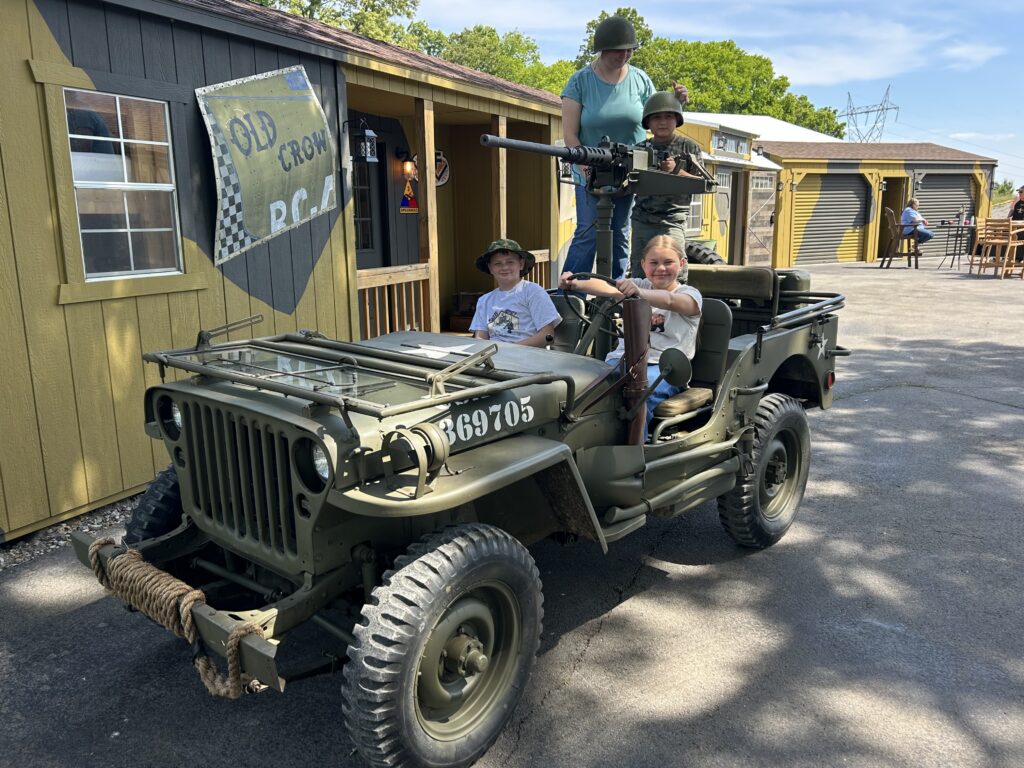 Children and family posing inside a historic WWII military Jeep display at Terra Bellum