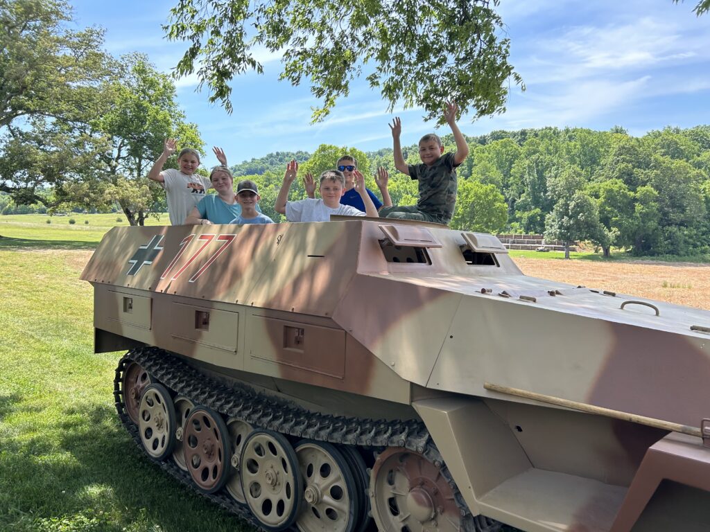 Group of children riding in a historic WWII Sd.Kfz. 251 half-track during an educational group tour at Terra Bellum