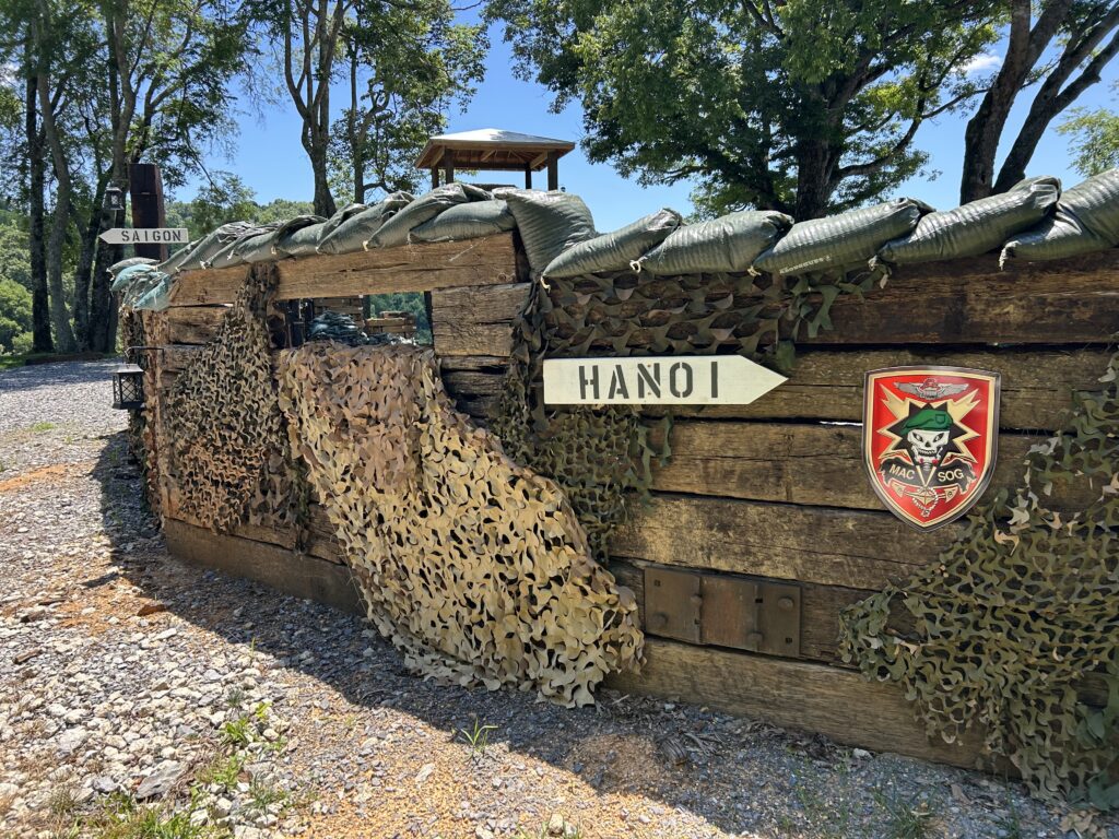 Vietnam War style sandbag bunker display with MACV-SOG insignia and directional signs at Terra Bellum