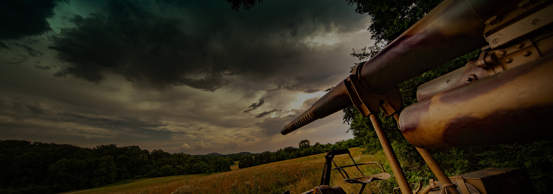 Dramatic angle of a historic German 88mm artillery gun barrel overlooking open fields at Terra Bellum